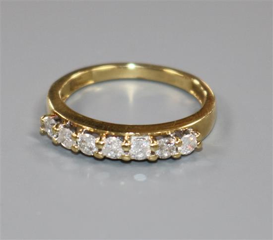 An 18ct gold and seven stone diamond half hoop ring, size M.